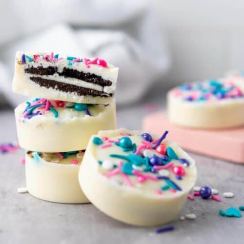 Stacked whitle chocolate covered oreos with sprinkles.