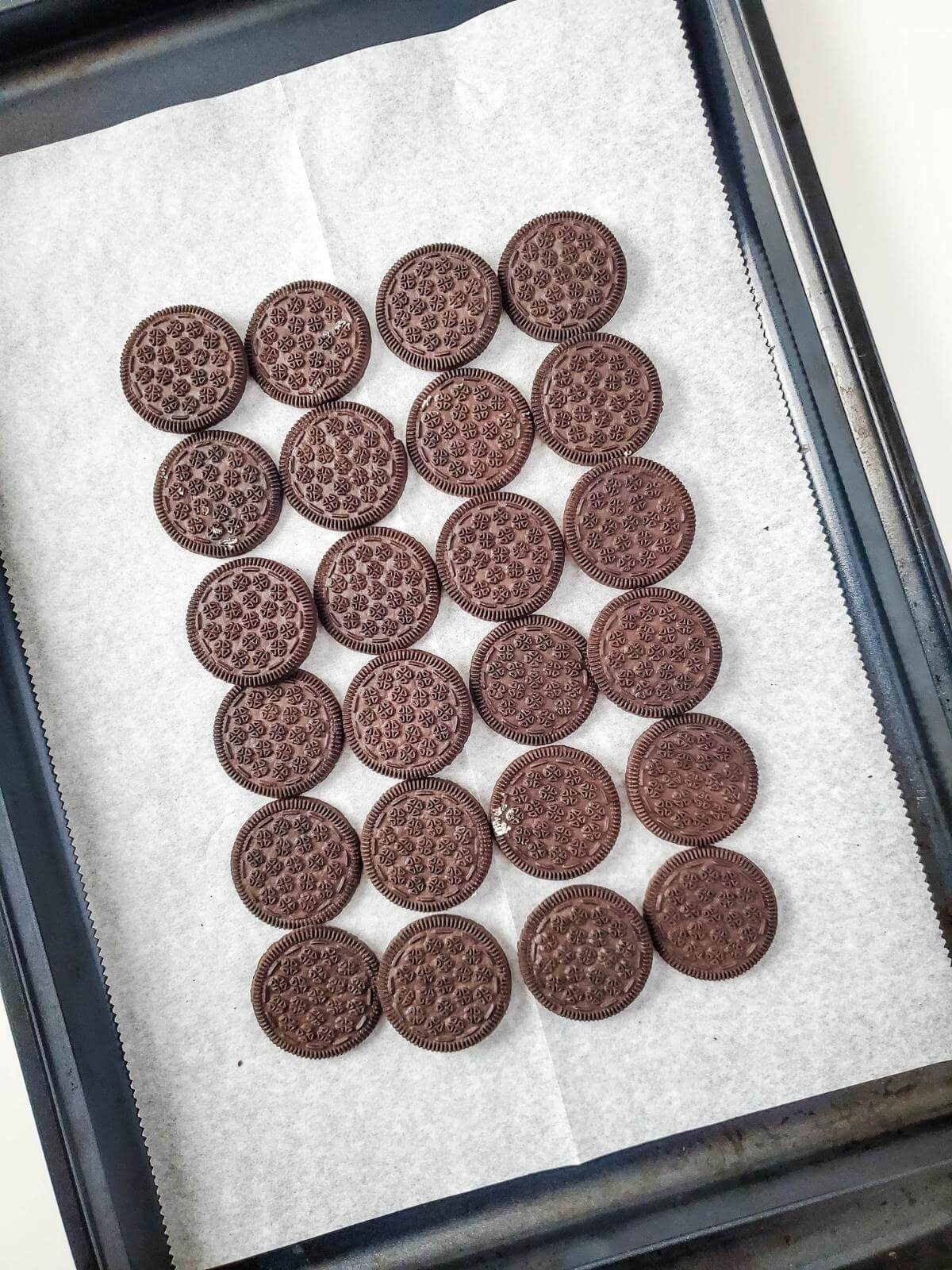 Oreos on a parchment paper lined baking sheet.
