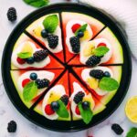 A watermelon pizza with fruit on top.